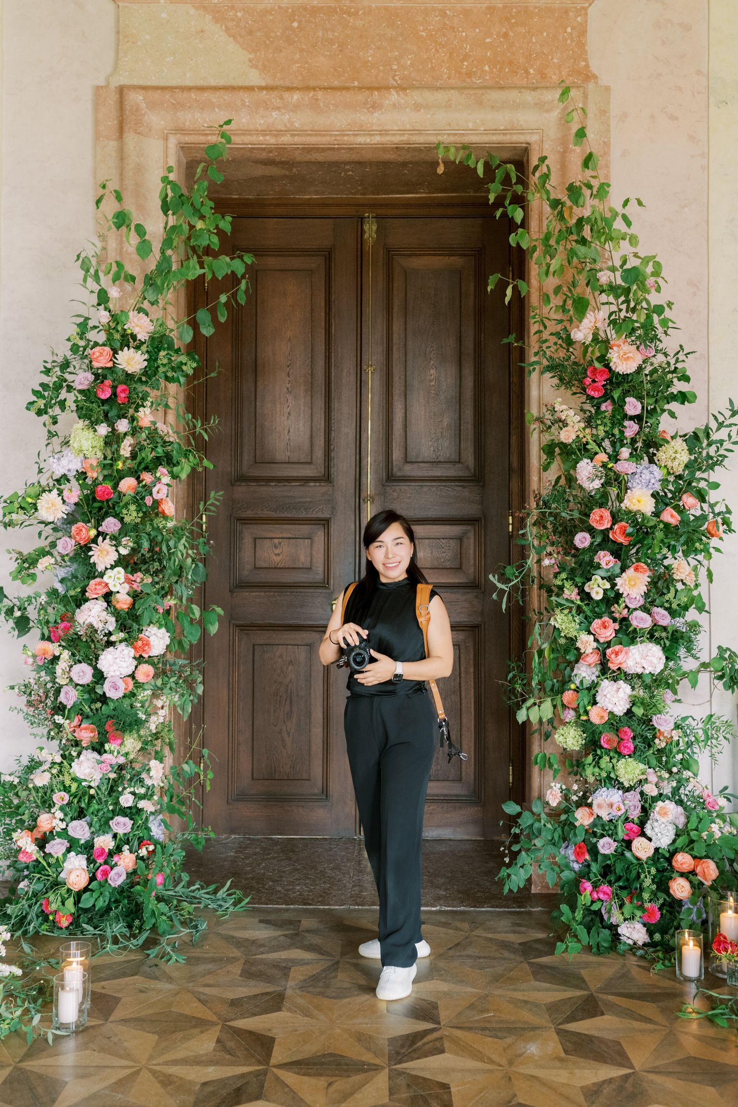 Bride in flower-adorned doorway at Schloss Eckartsau Austria styled shoot — destination wedding photography