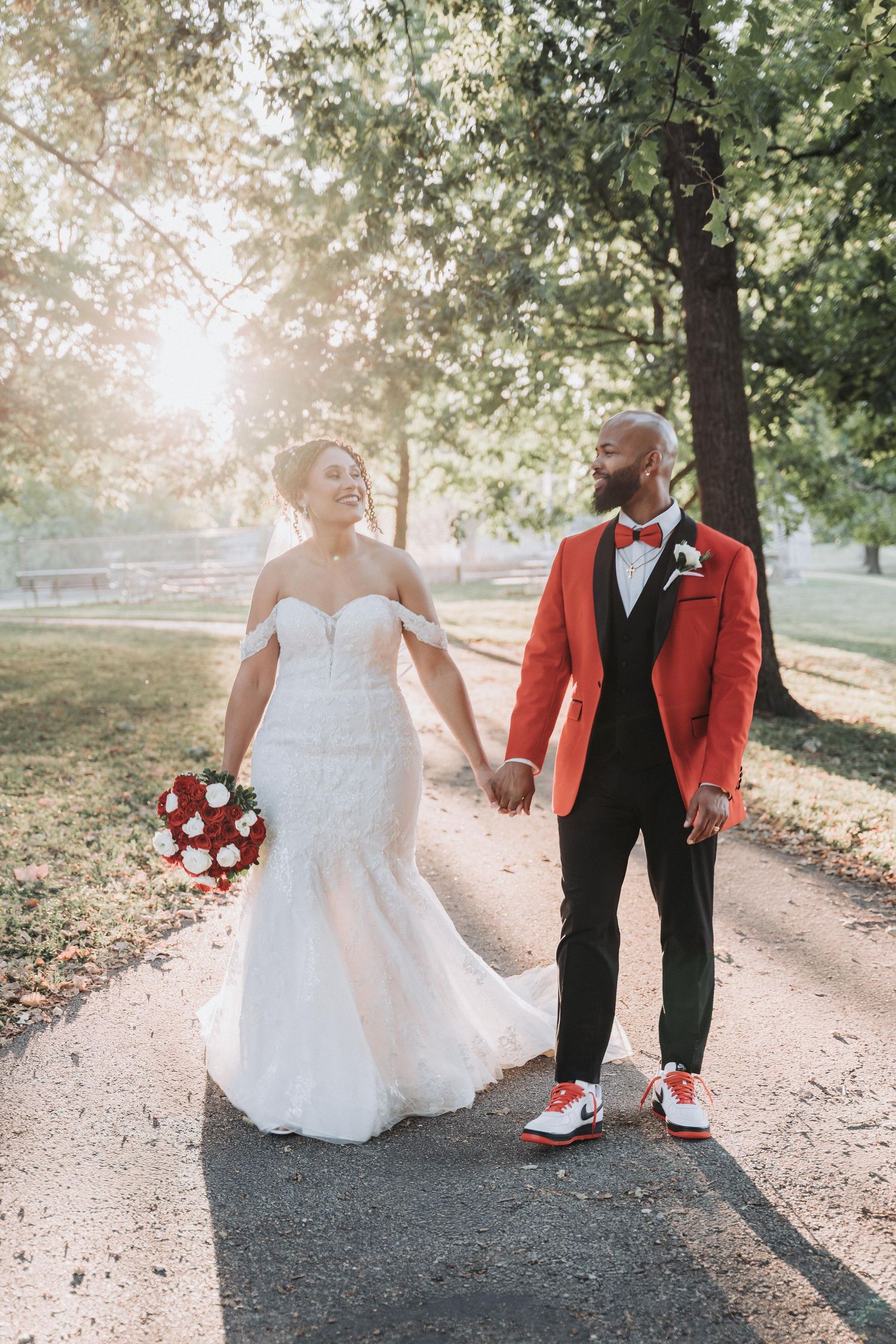A romantic wedding photo series showing a couple walking on a path with the bride in white and groom in red jacket and sneakers.