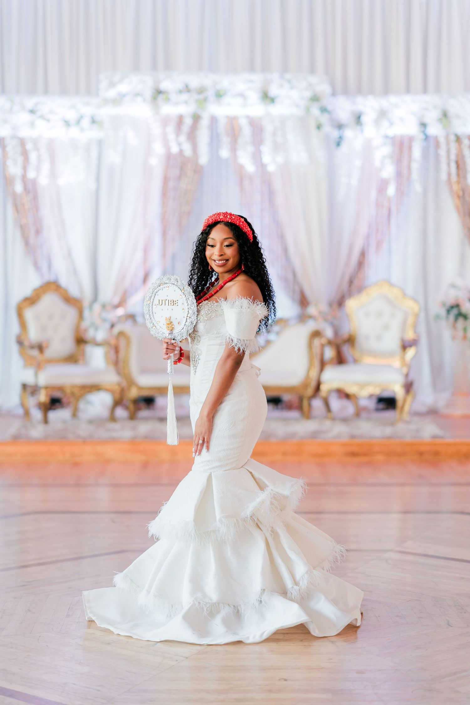 A bride poses in an ornate reception venue wearing a stunning mermaid-style wedding gown.