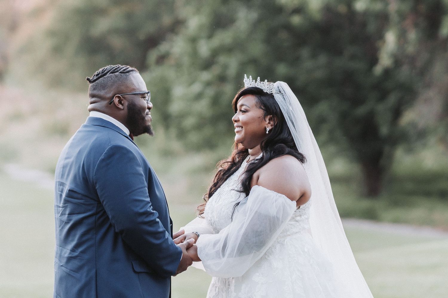 Intimate moment between bride and groom exchanging vows outdoors.