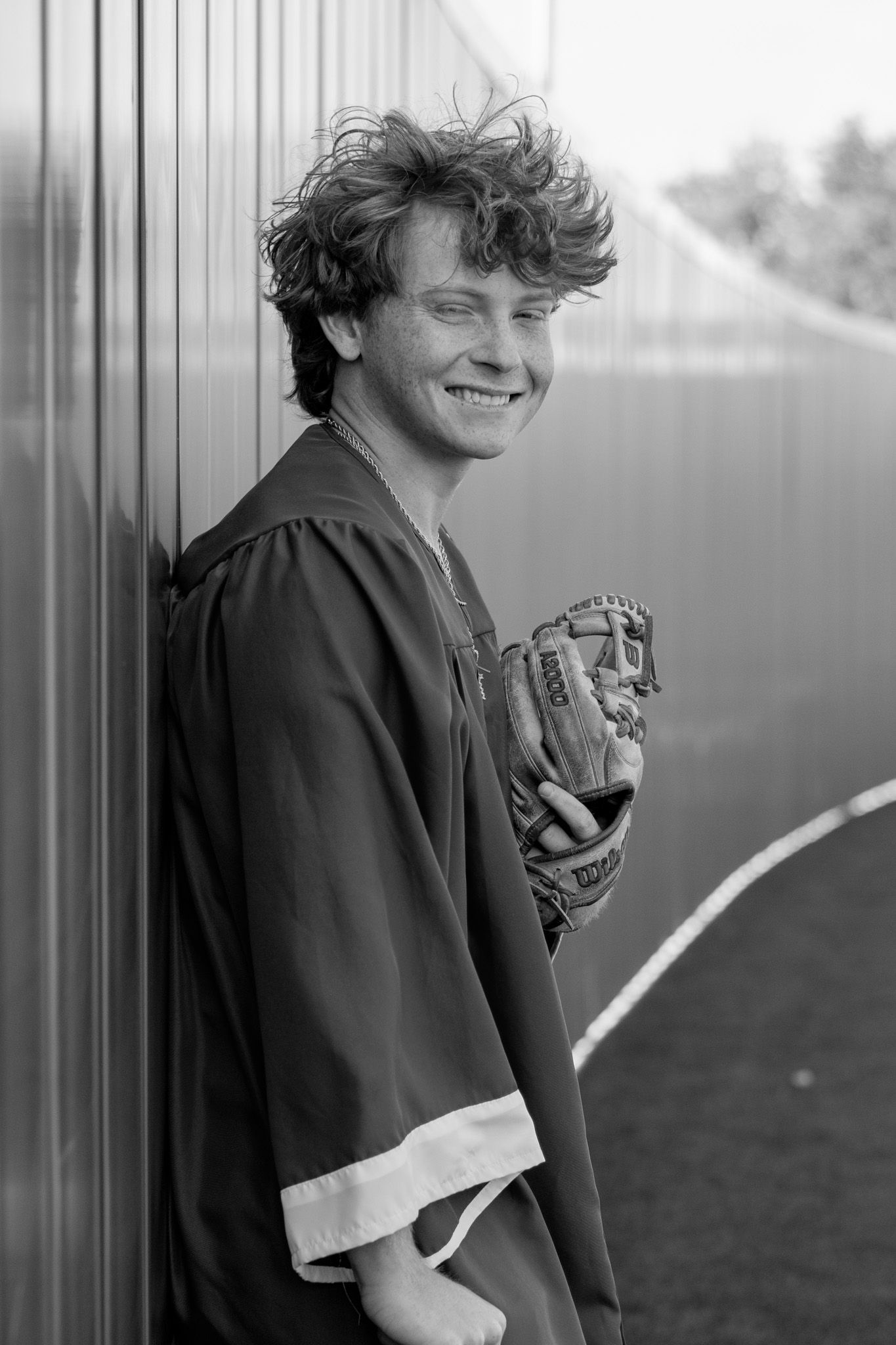 A sequence of black and white photos showing a baseball player in casual attire with a glove smiling and posing outdoors.