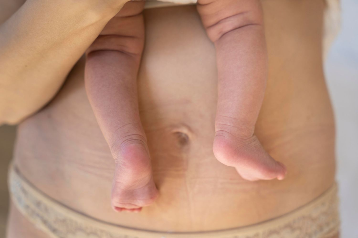 Close up of baby's feet on mother showing her belly.