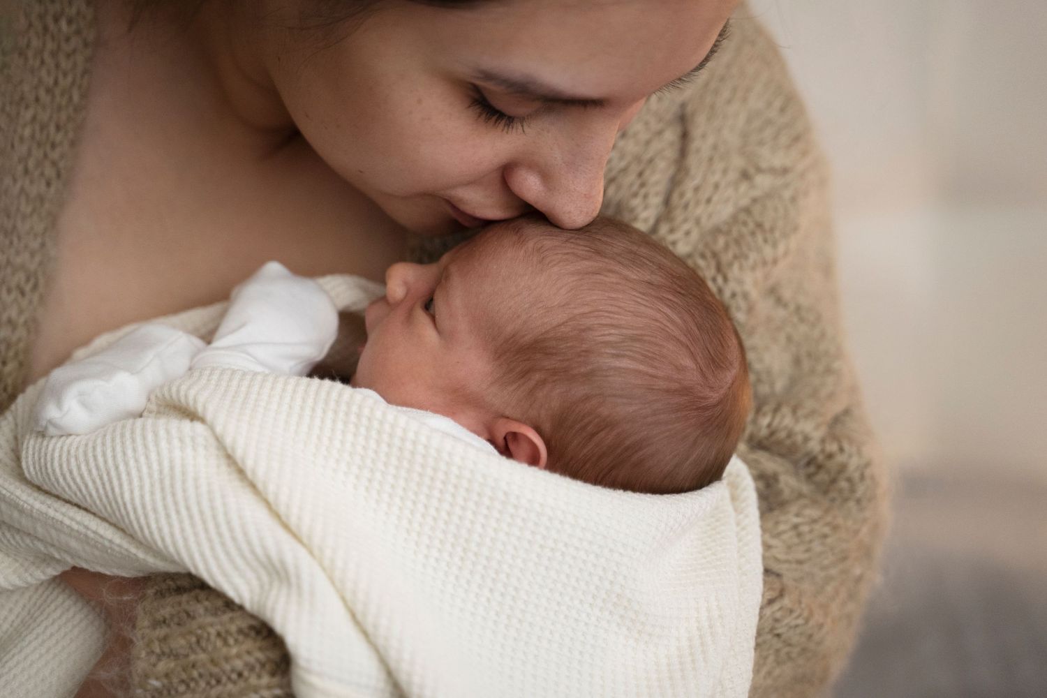 Mother kissing baby after breast feeding