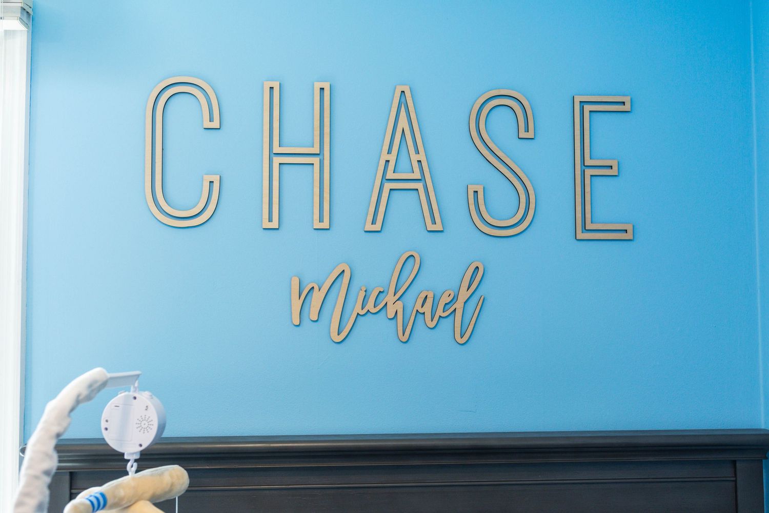 Baby nursery blue wall with wooden letters spelling Chase Michael above a crib during an at home newborn session Philadelphia, PA.