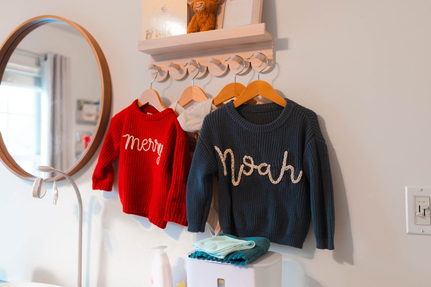 Personalized name sweaters for siblings Merry and Noah hanging in a nursery in Pottstown, PA.