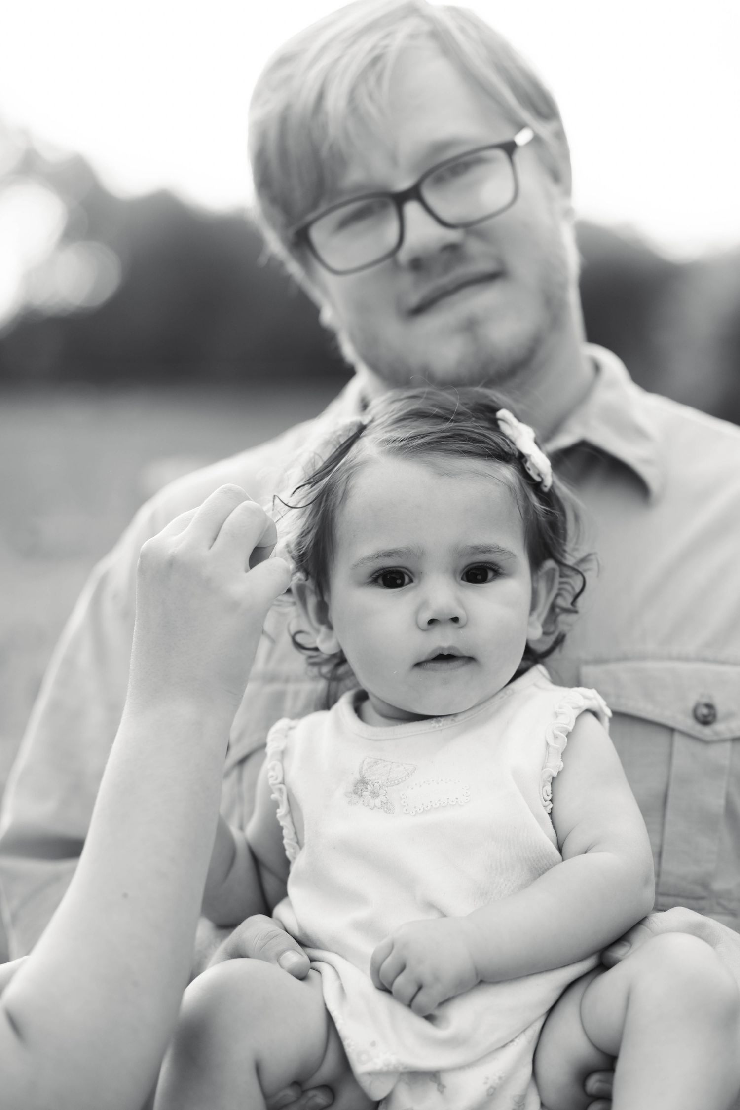Black and white photo of a father holding his baby daughter outdoors during a family portrait session in Pekriomenville, PA.