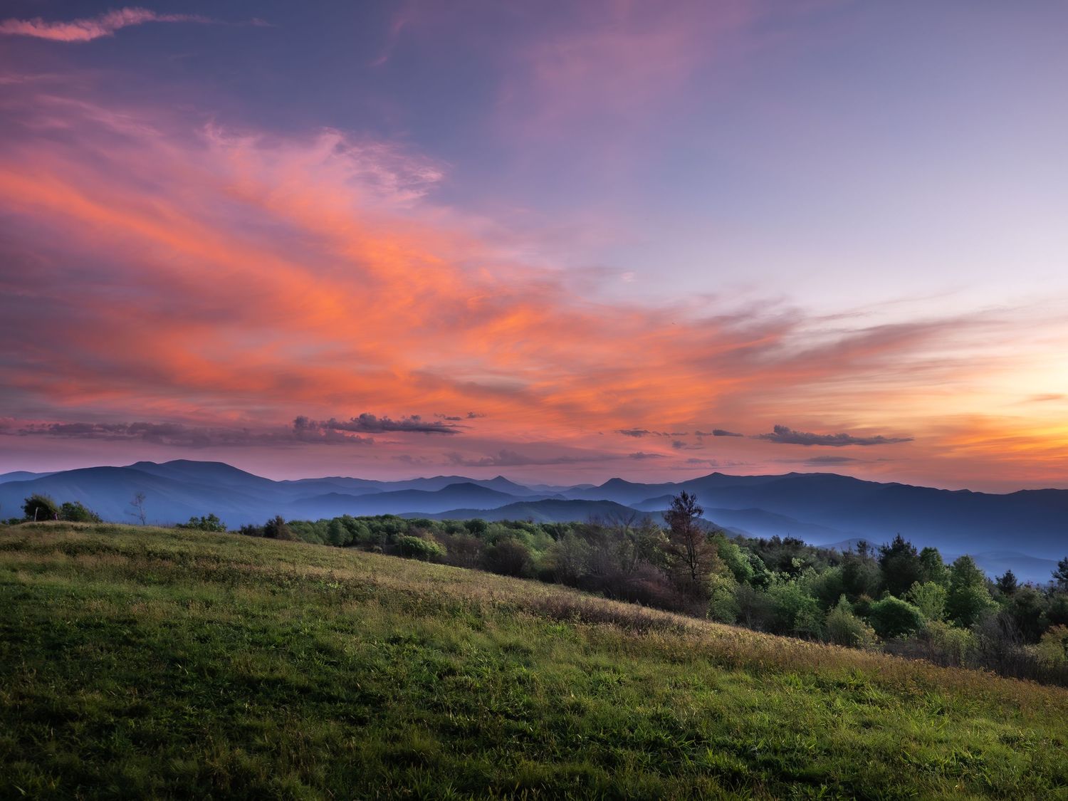 Photo of The Beauty Spot along the Appalacian Trail. Scene is a dramatic sunset sky of red, orange, blues looking over smoky mountains.