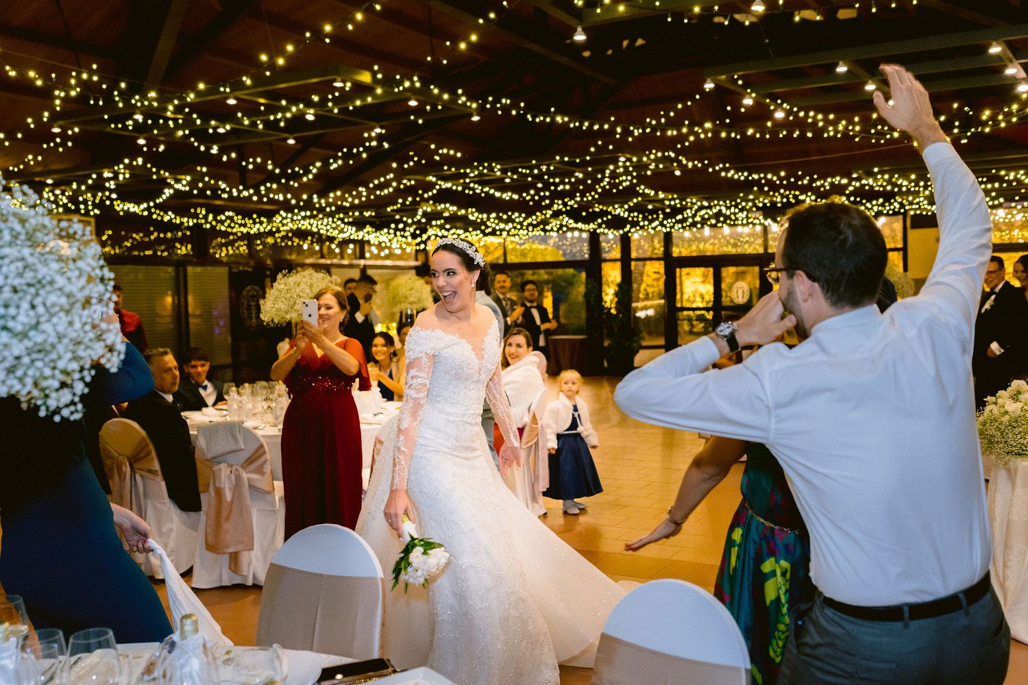 String lights illuminate an enchanting wedding reception with glowing decor creating a magical atmosphere at a barn venue.