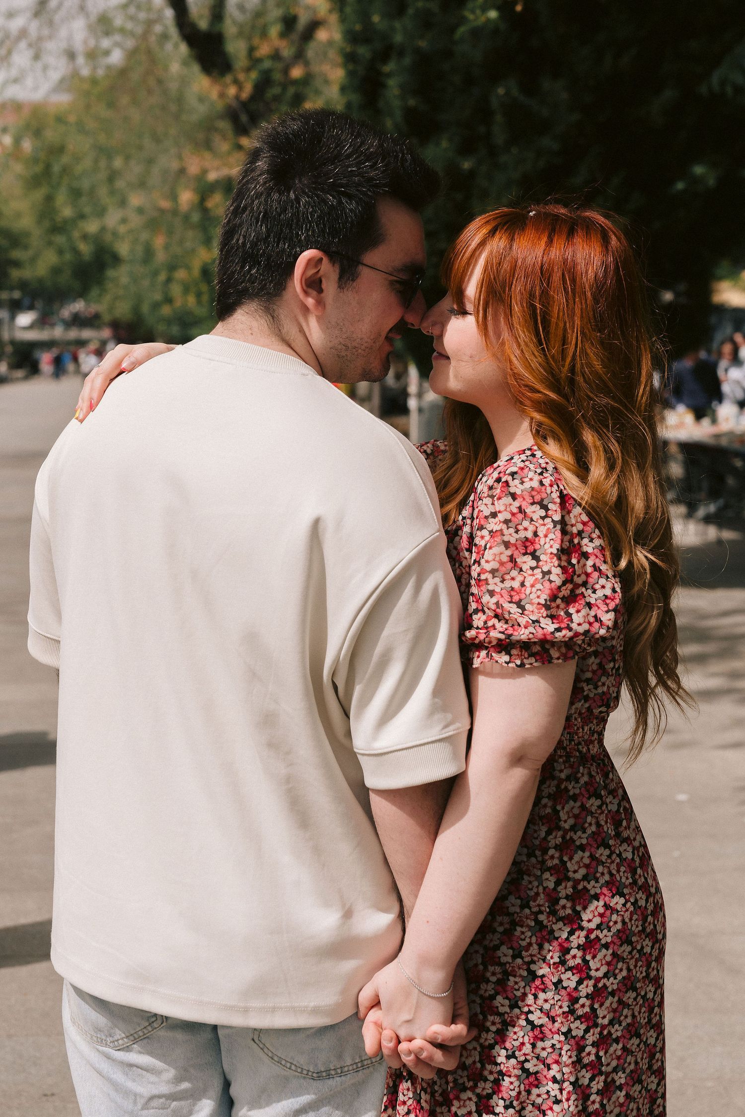 A romantic couple shares an intimate moment in a European park setting.