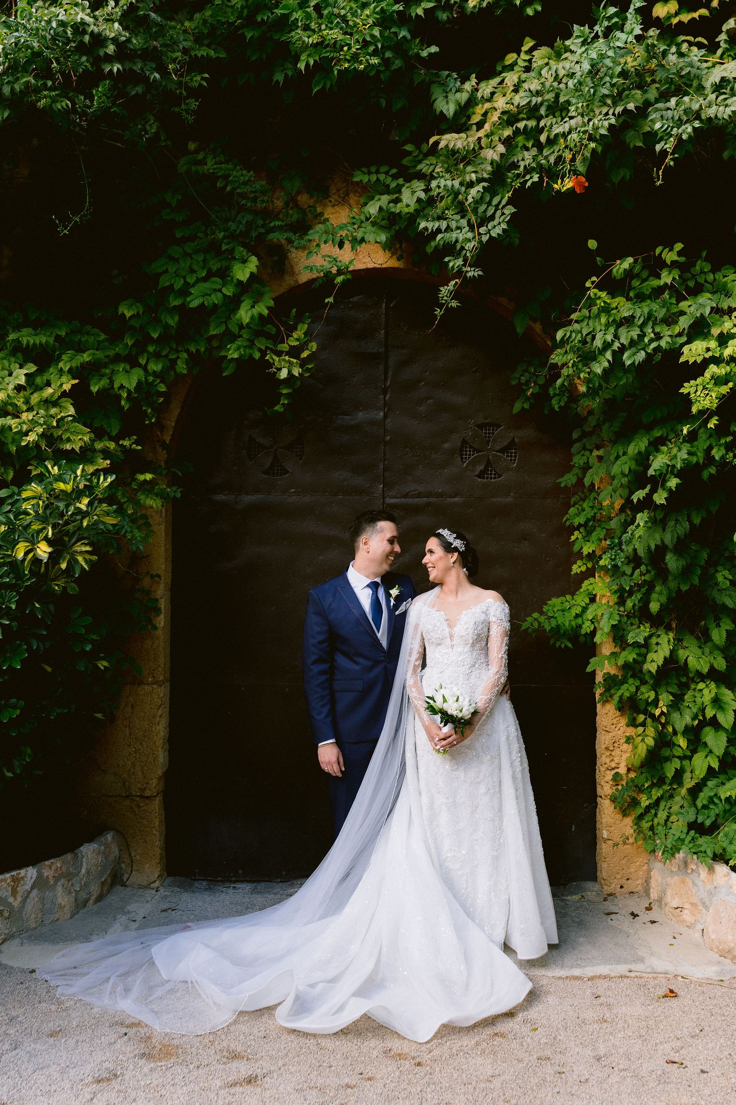 A romantic wedding sequence shows a bride and groom posing under stone archways surrounded by lush greenery.