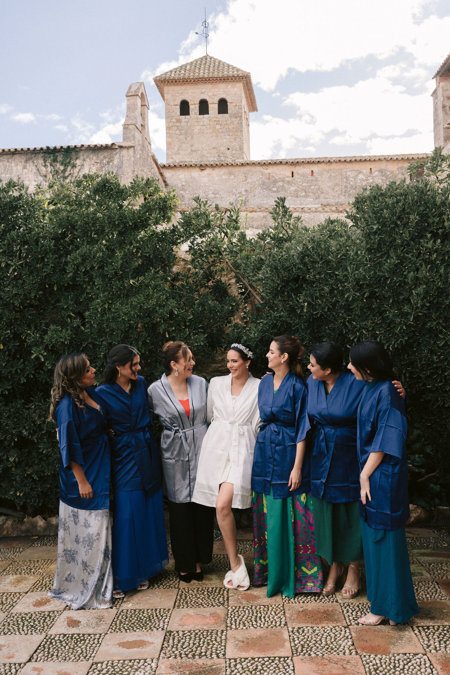 Novia preparándose con amigas en habitación con vista al Mediterráneo en el Castell de Tamarit