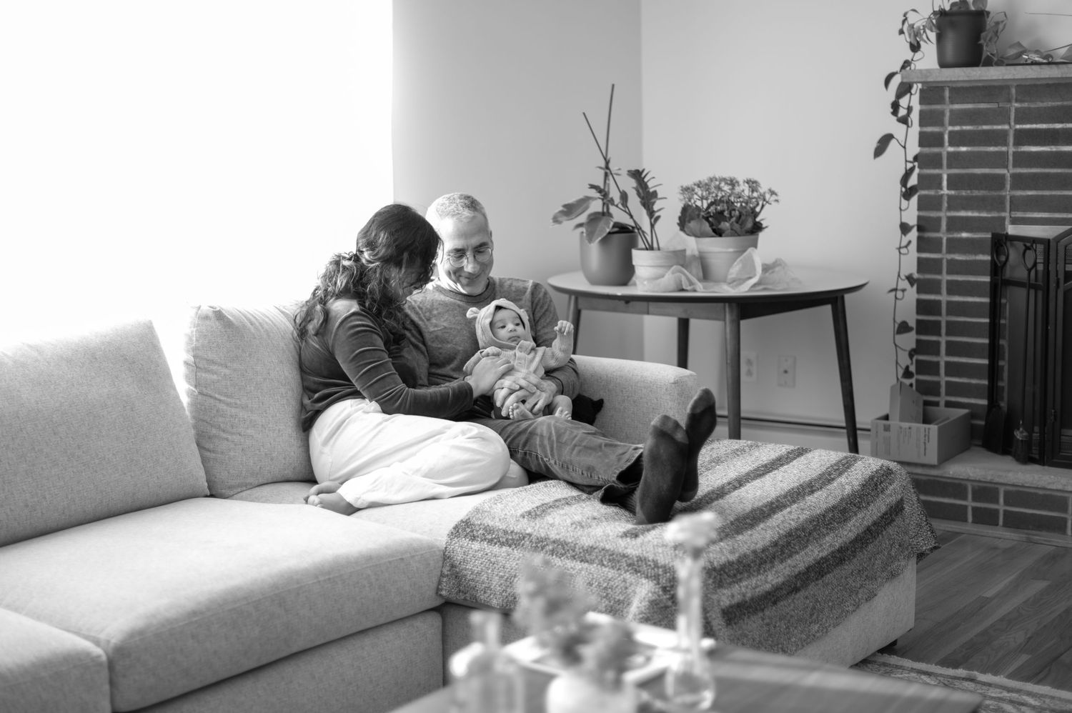 Black and white photo collage showing tender moments between people relaxing together on a couch at home.