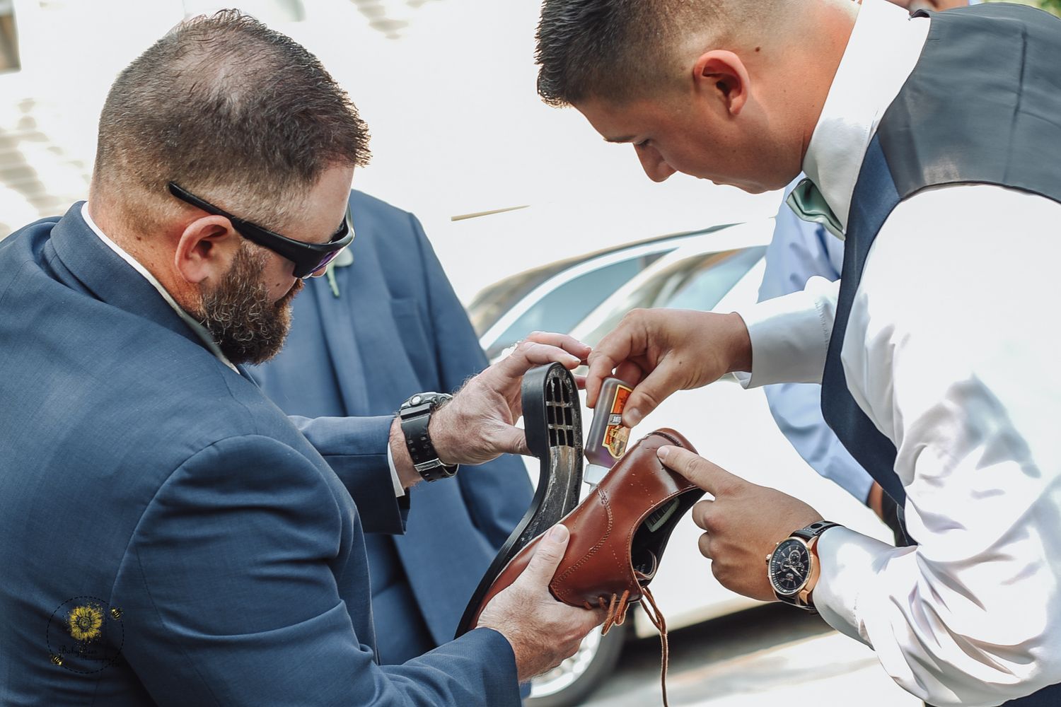 Wedding preparations showing details of suit and tie adjustments.
