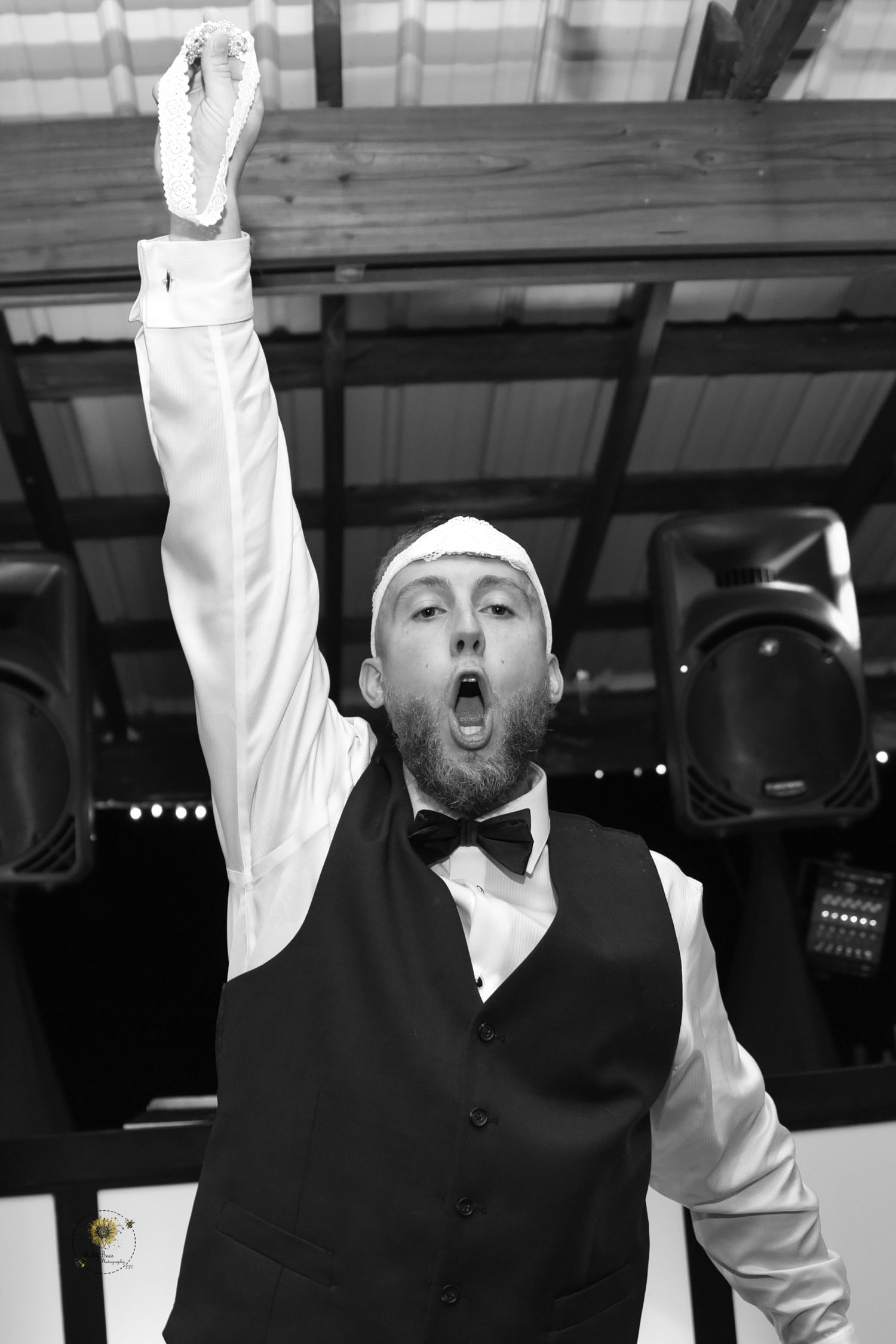 Black and white photo showing an enthusiastic celebration moment at a wedding reception.