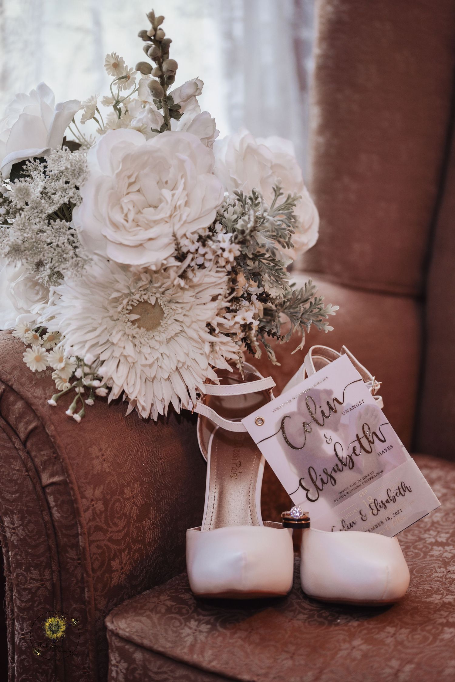 Wedding details featuring white bridal shoes and delicate floral bouquet with name tags.