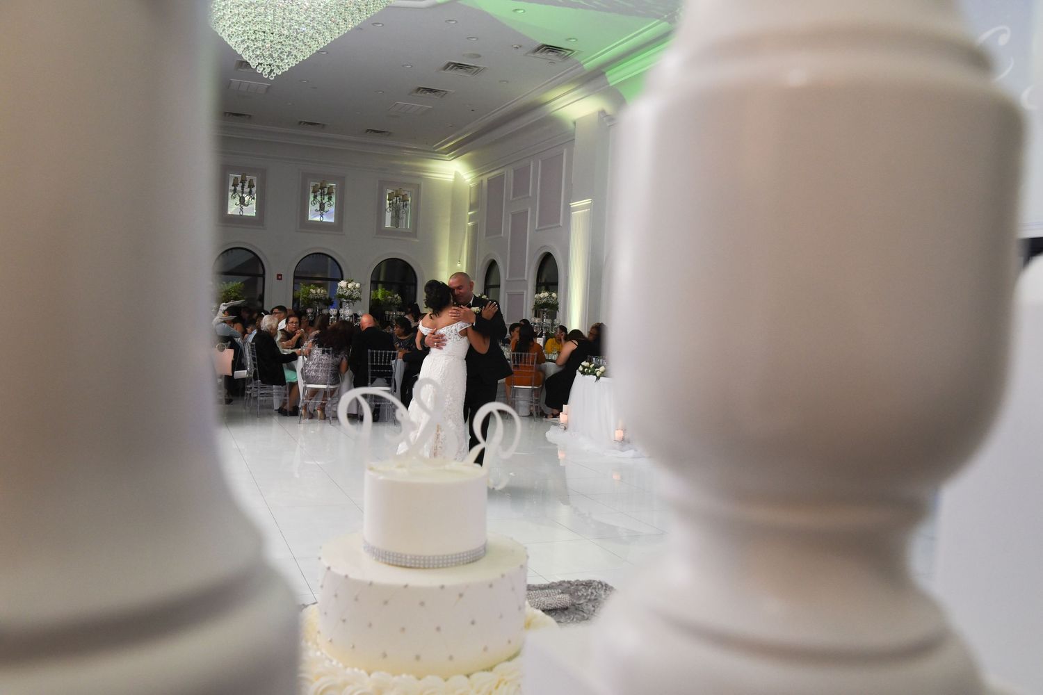 Modern white wedding venue interior with elegant columns and architectural details.