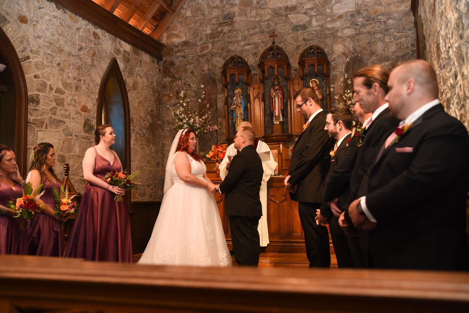 Elegant stone church interior with arched architecture during evening wedding ceremony.