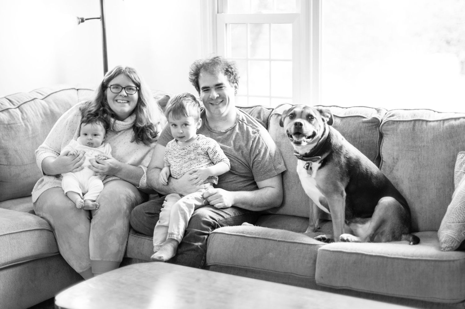 Black and white photo series showing people relaxing on couches with their pets in cozy home settings.