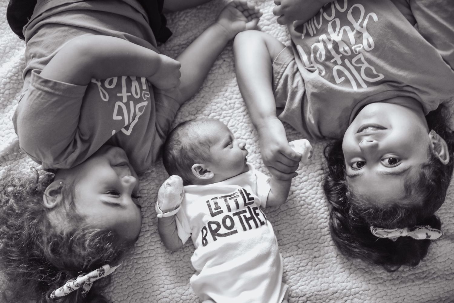 A series of black and white photographs showing a sleeping baby in various peaceful poses on a soft surface.