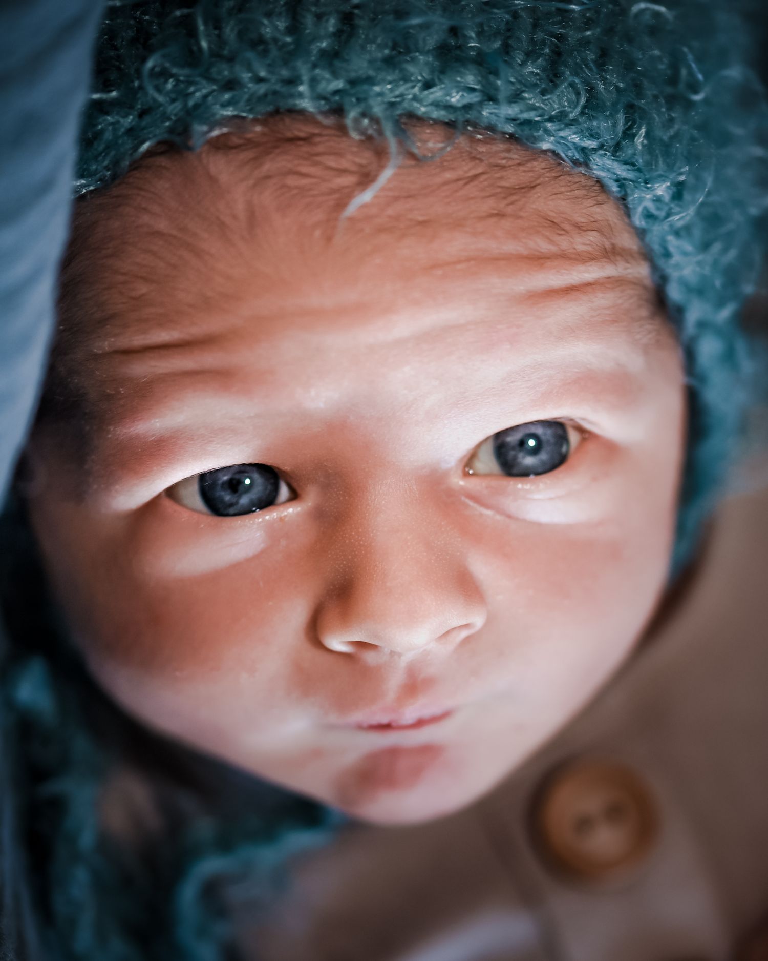 Close-up artistic portrait of eyes and face in a dramatic blue tinted lighting effect.