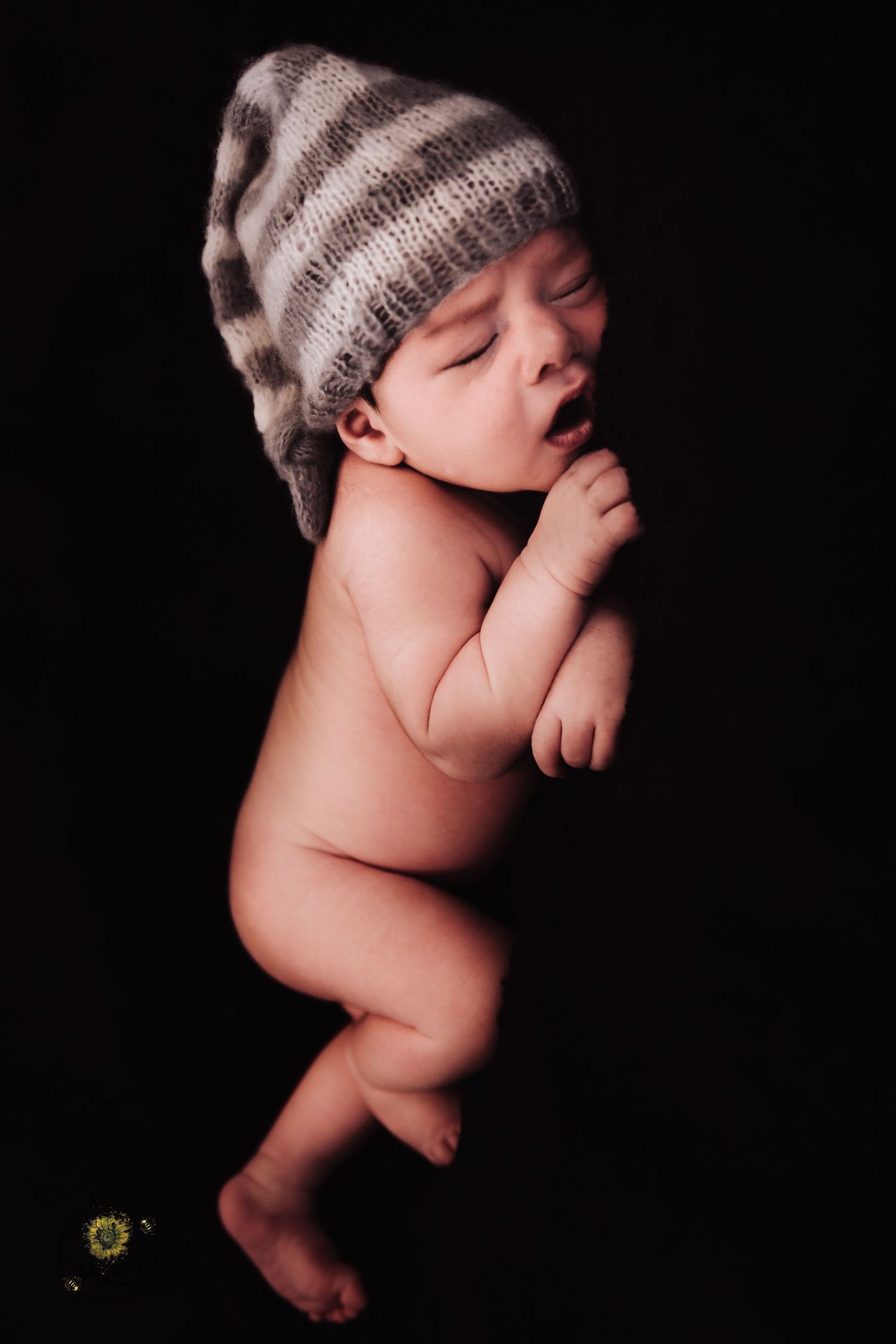 Sleeping newborn baby wearing knit hat in artistic black and white photo series showing different angles.