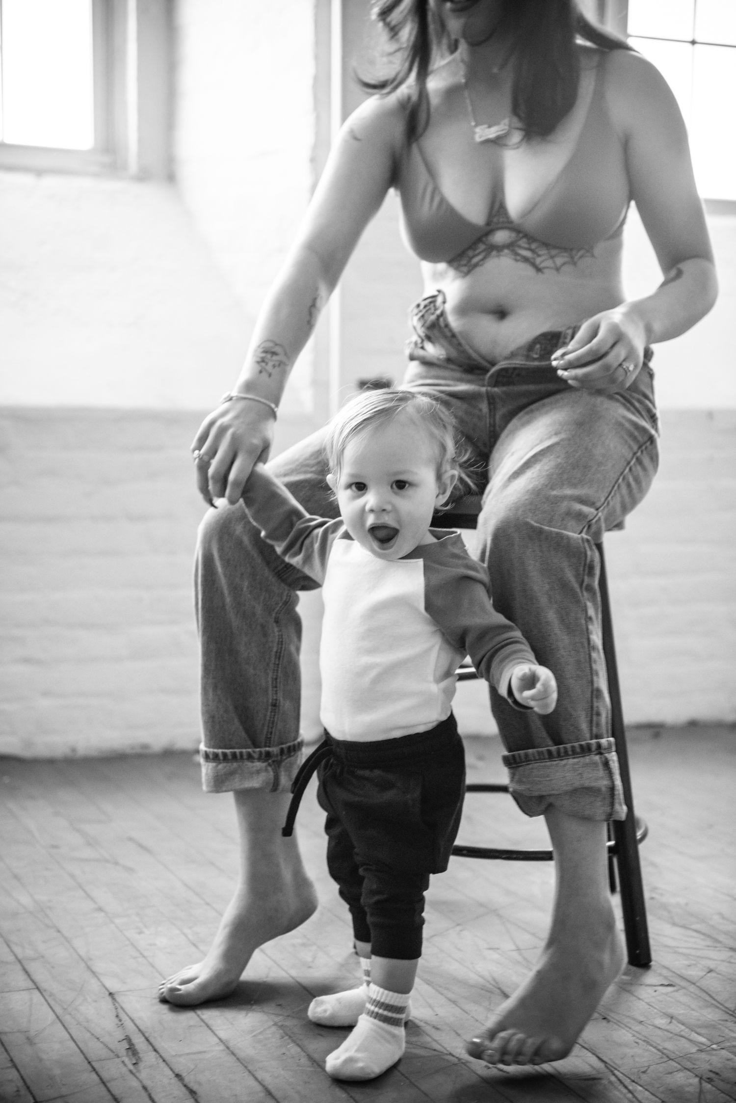 Black and white photo series showing baby's first steps with parent's supportive hands guiding the learning process.