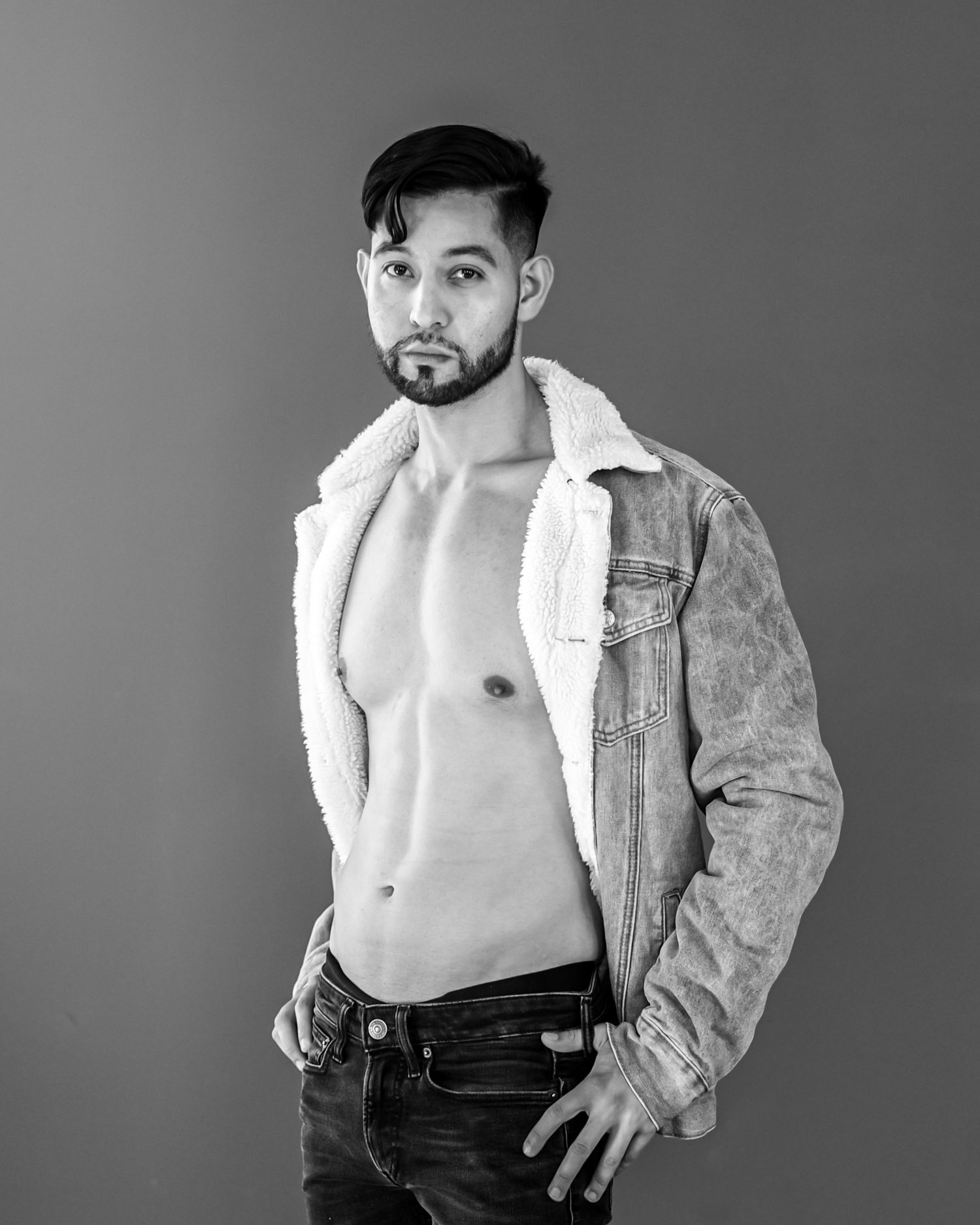Black and white artistic portrait series showing a figure in an open white shirt and dark pants against a neutral background.