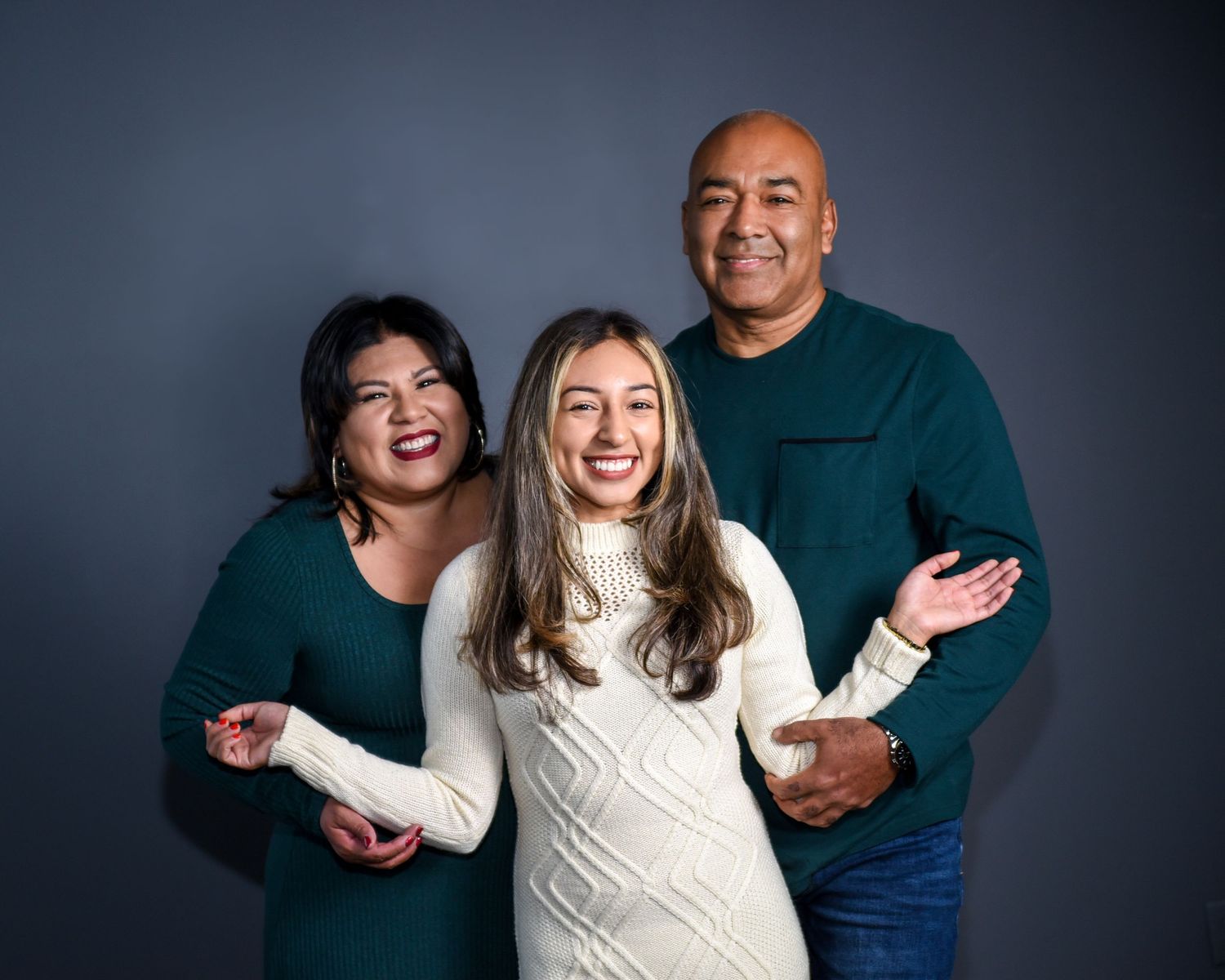 A sequence of four candid studio portraits showing playful interaction between two people against a dark background.