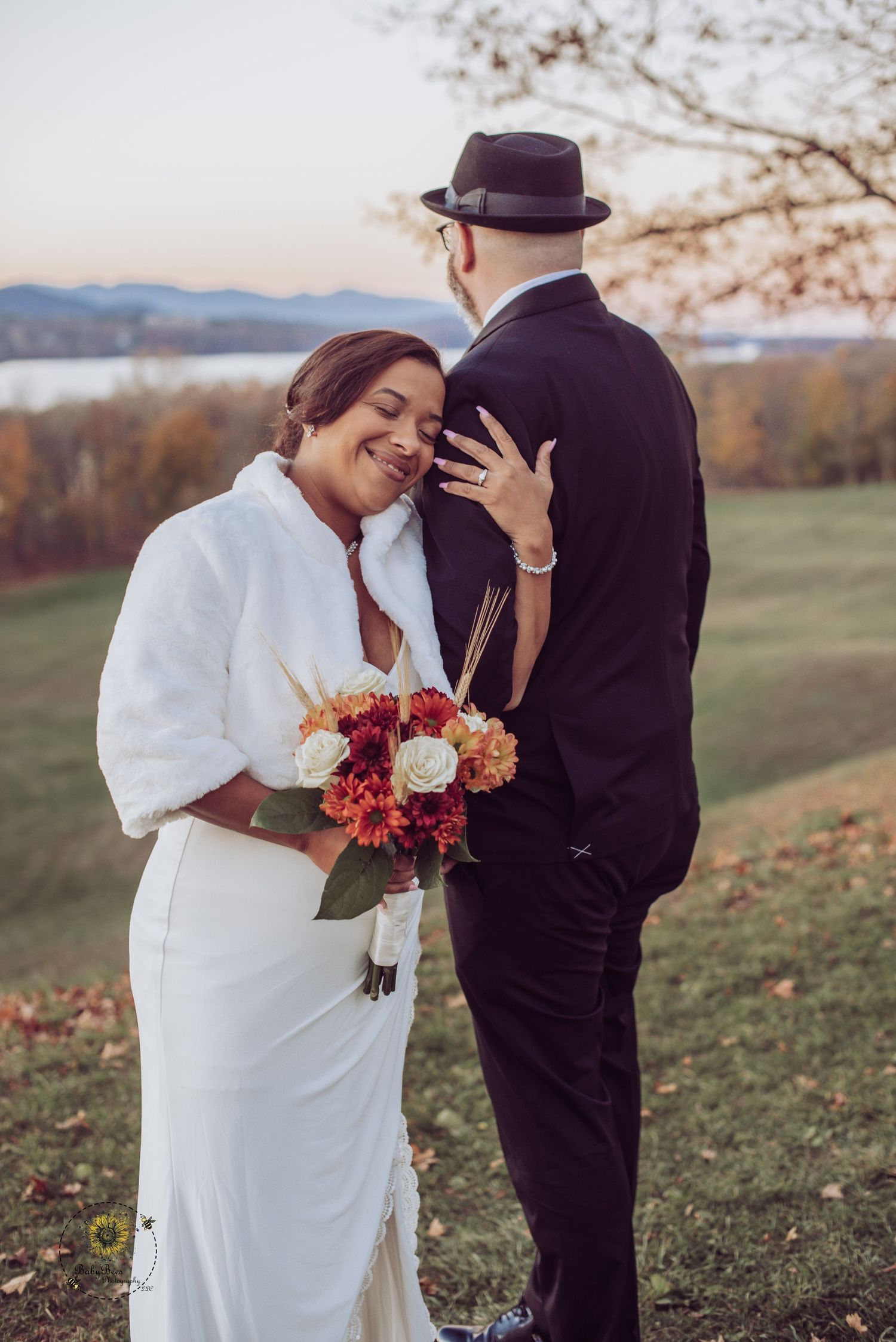 Romantic autumn wedding photoshoot in a field with colorful fall foliage.