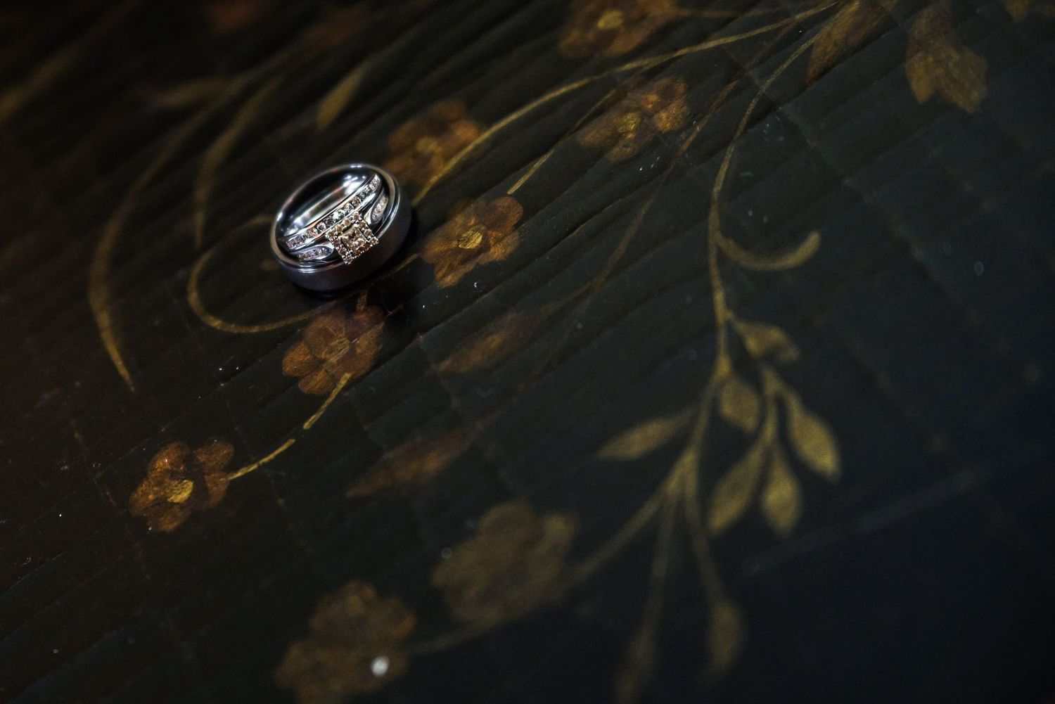 Artistic detail shot of delicate floral patterns in dark moody lighting.