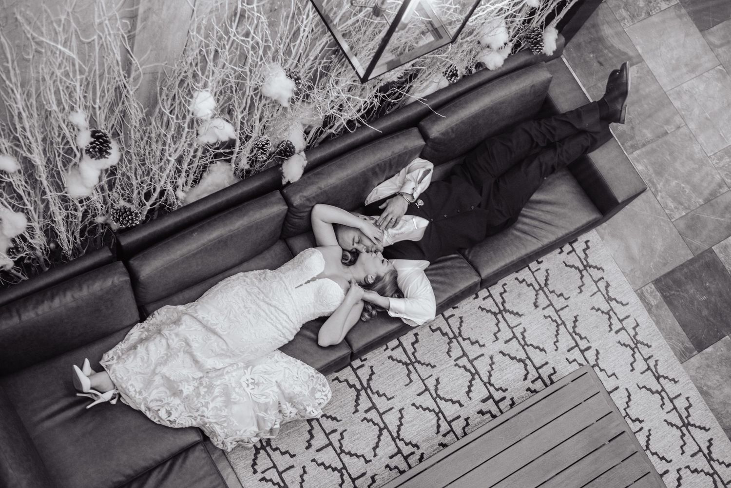 Black and white wedding photos showing playful poses on patterned carpet.