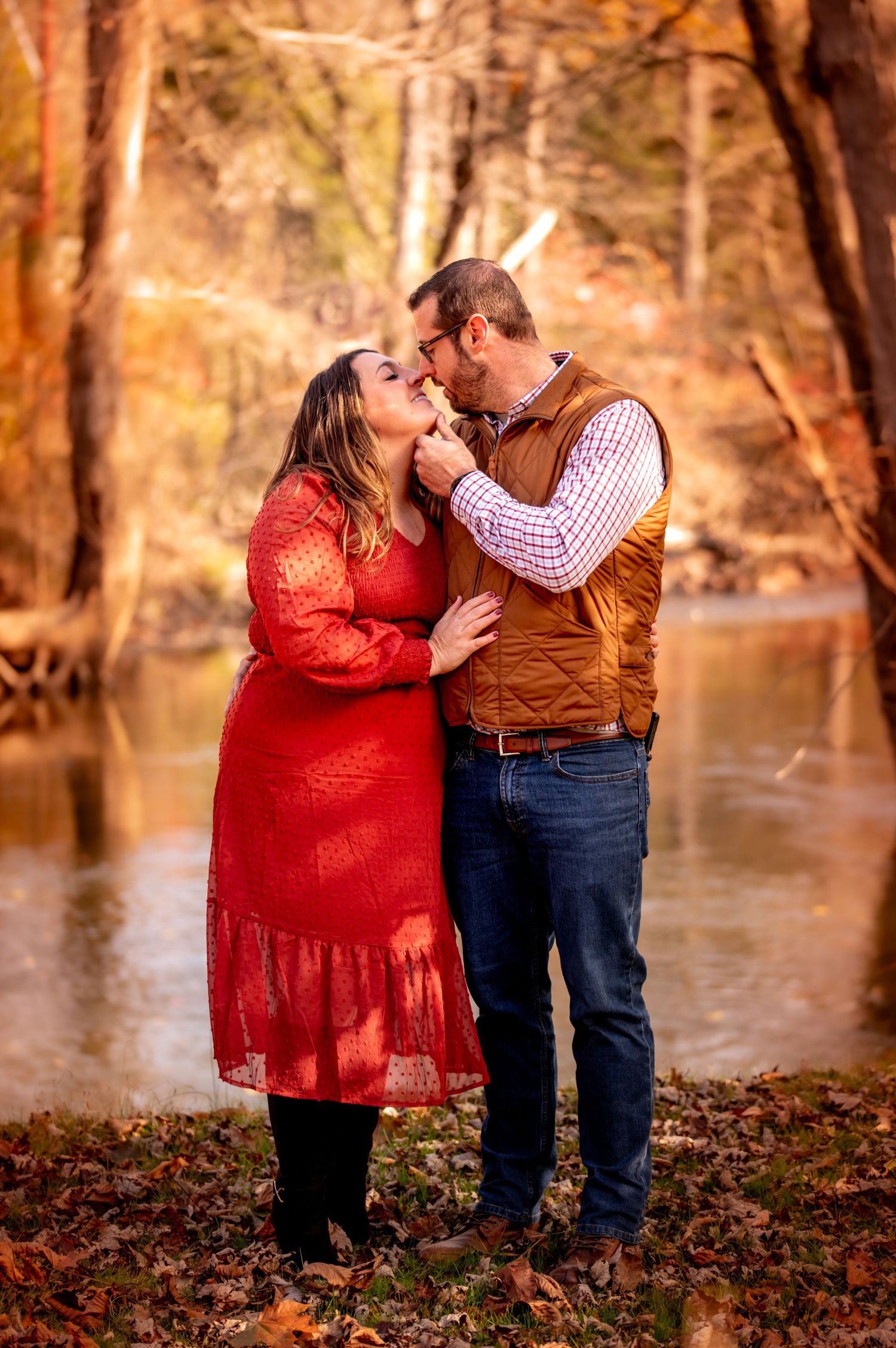 Romantic autumn photo sequence of couple embracing by a lake with fallen leaves and golden trees in background.