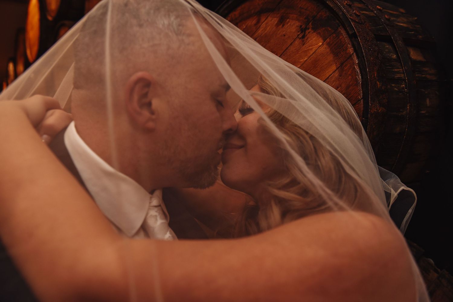 Intimate wedding couple silhouettes sharing tender moments in warm lighting.
