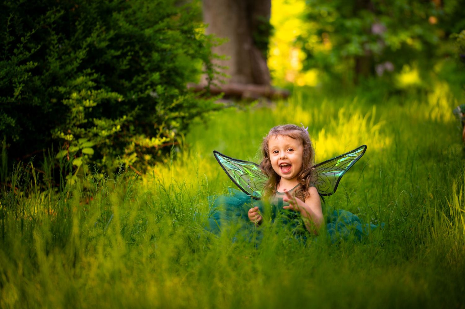 A joyful child plays outdoors in a lush green garden setting with vibrant yellow wildflowers in the background.