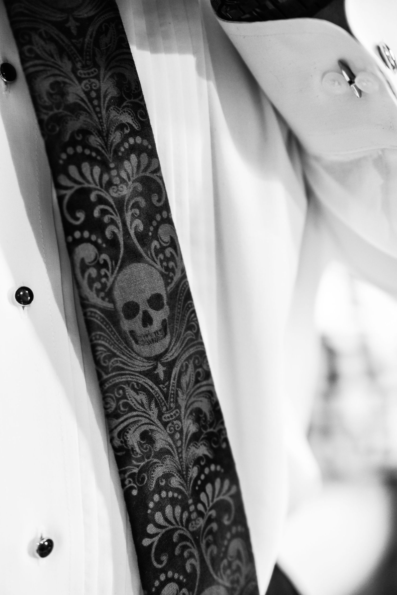 Black and white wedding decor features elegant skull and floral damask wallpaper pattern.