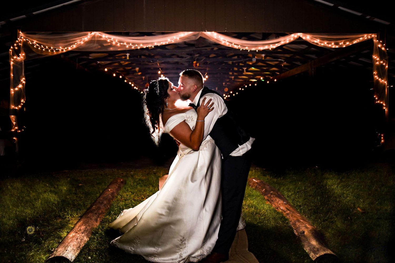 Romantic nighttime wedding photos with string lights creating a magical atmosphere.