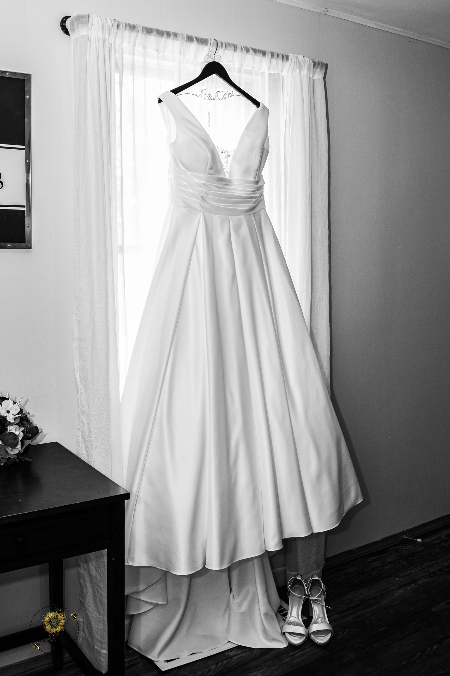 Wedding dress and shoes displayed elegantly in black and white photography.