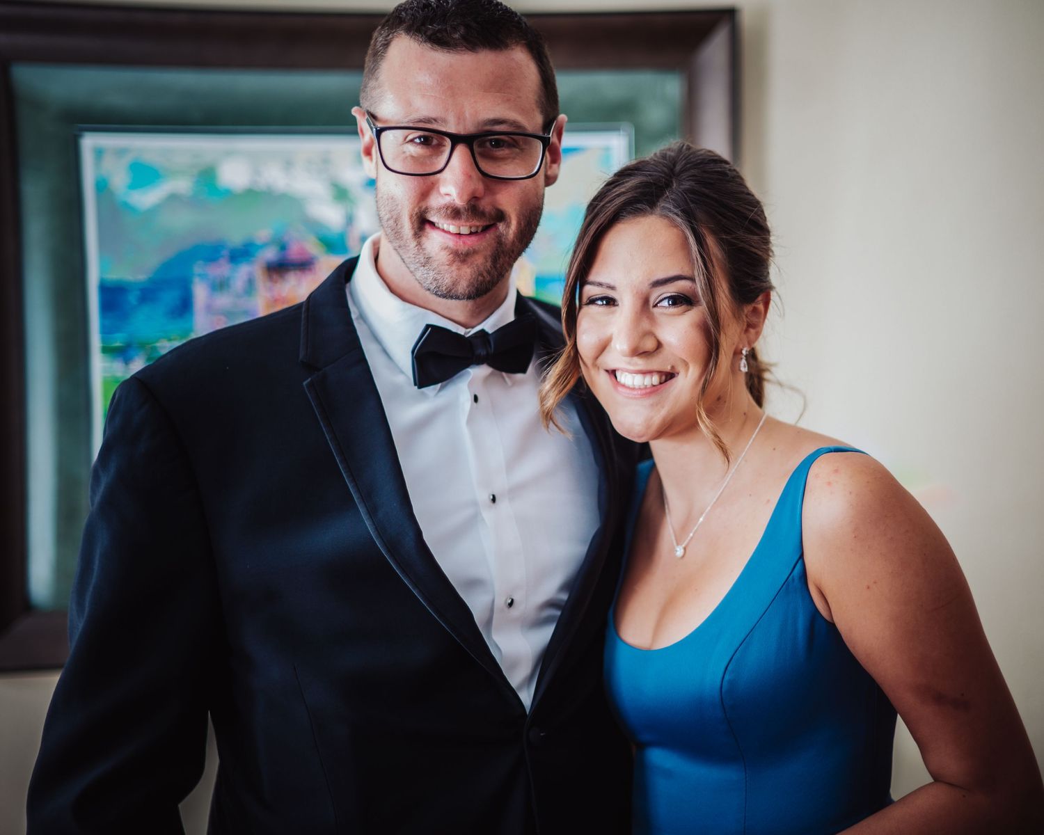 Wedding party members in formal attire posing against neutral background.