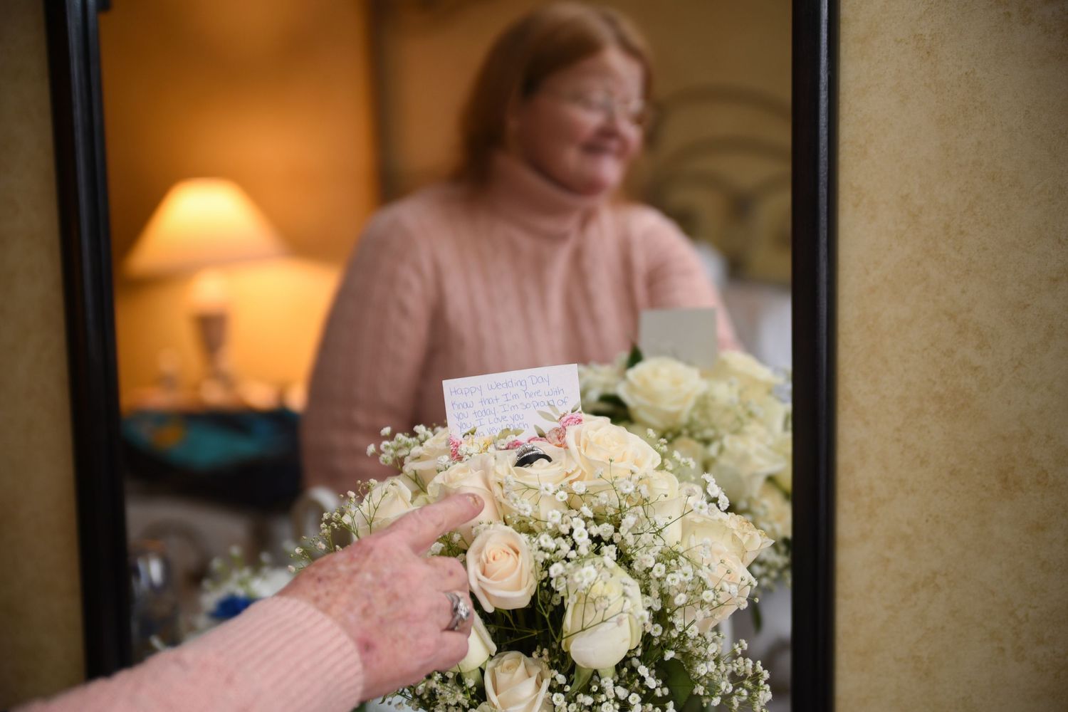 Elegant white floral centerpieces with roses and baby's breath at wedding reception.