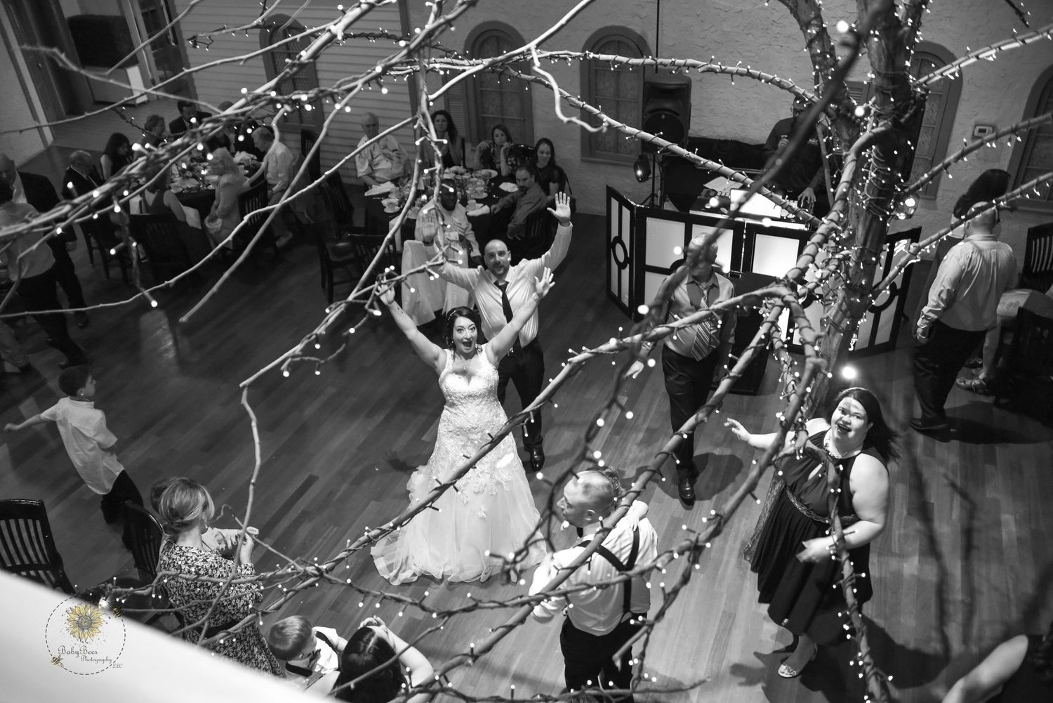 Wedding reception venue decorated with twinkling lights and floral arrangements.