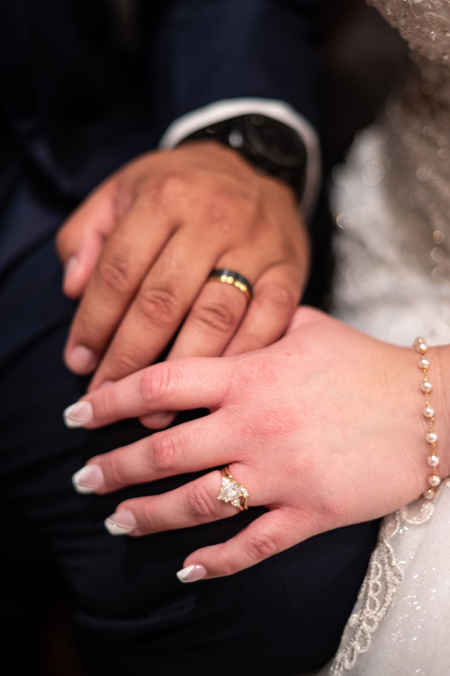 Close-up shots of bride and groom's hands with wedding rings and delicate bracelet.