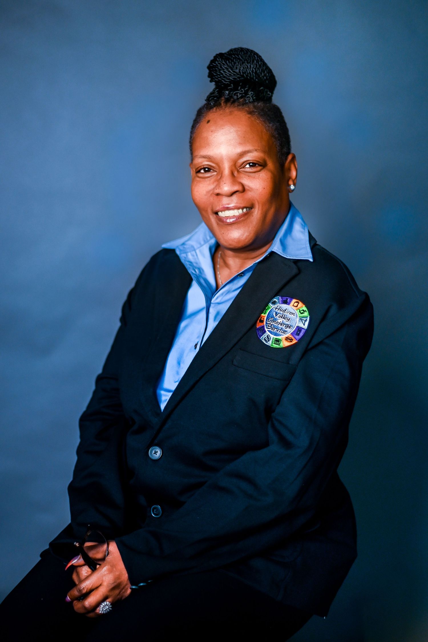Professional studio portrait series showing a person in a navy blazer and light blue shirt against a blue backdrop.
