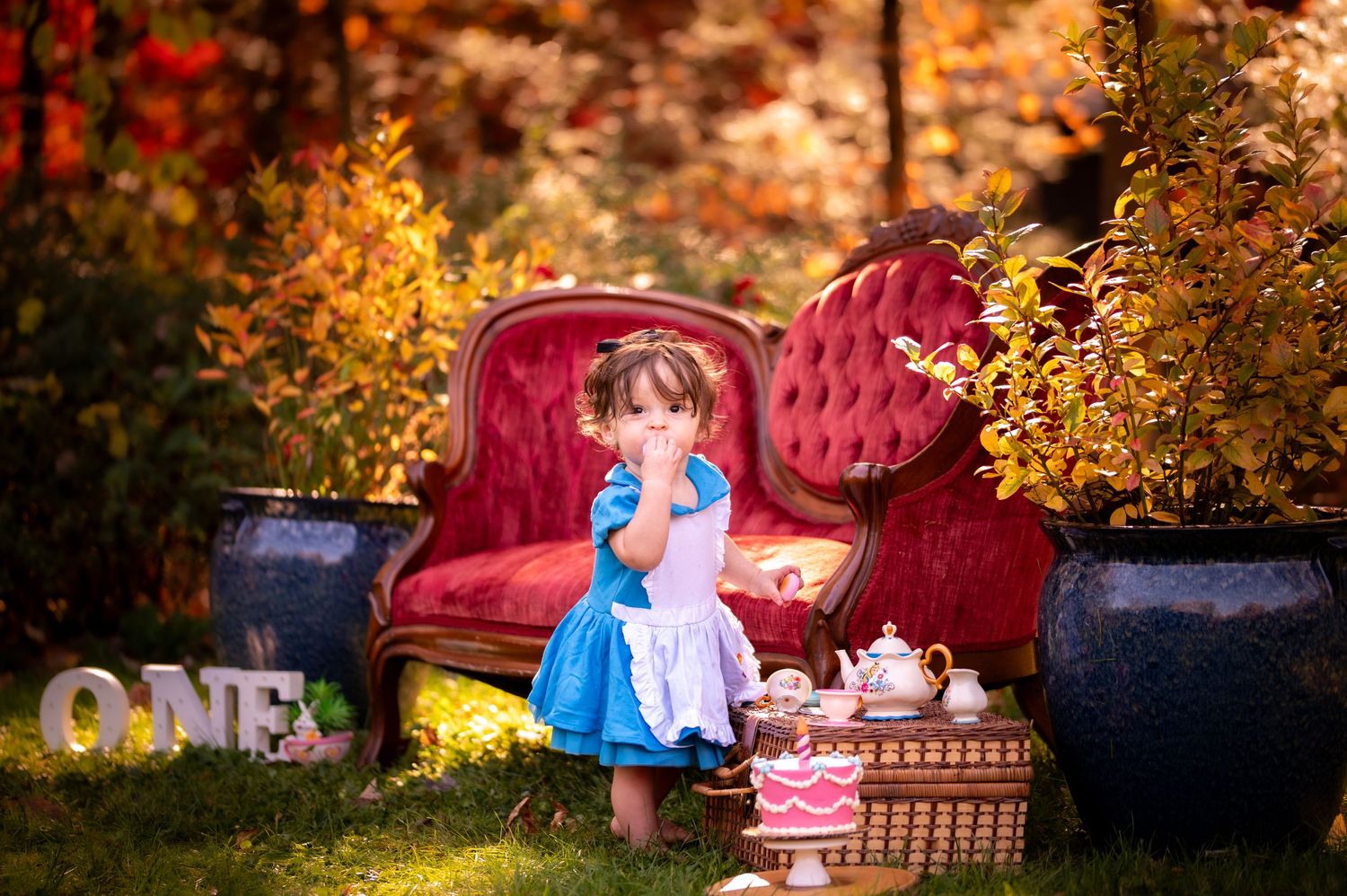 A cozy outdoor tea party setup with vintage furniture and autumn foliage creating a whimsical garden scene.