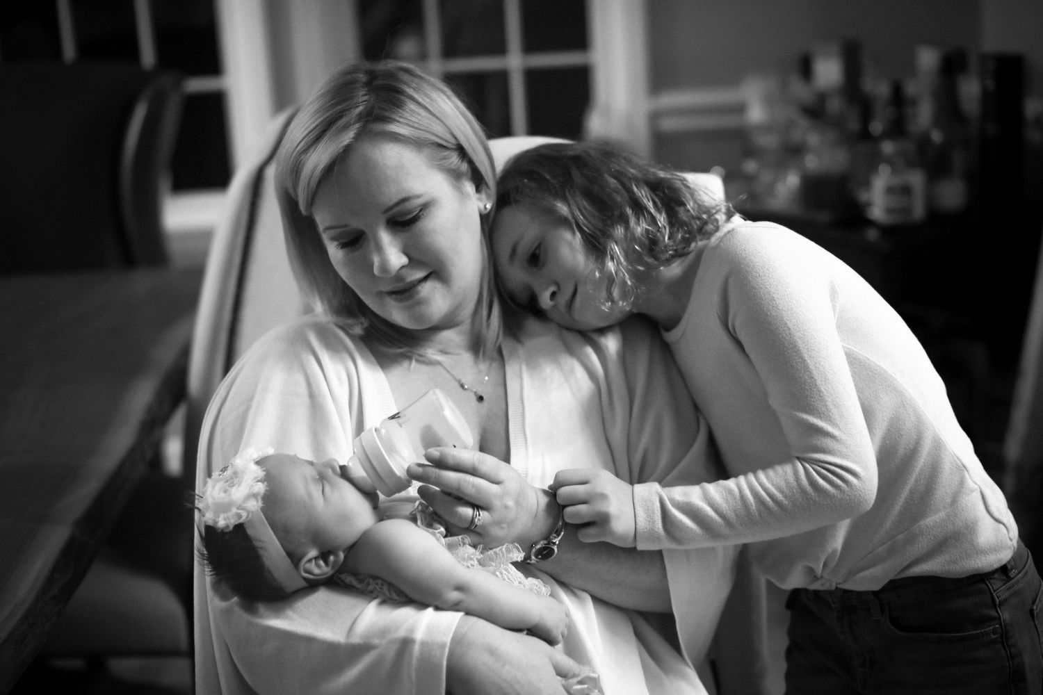 Black and white photo series showing tender moments between parents and newborn babies in hospital settings.