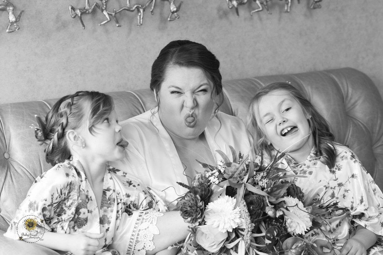 Wedding party lying down for creative black and white portrait with flowers.
