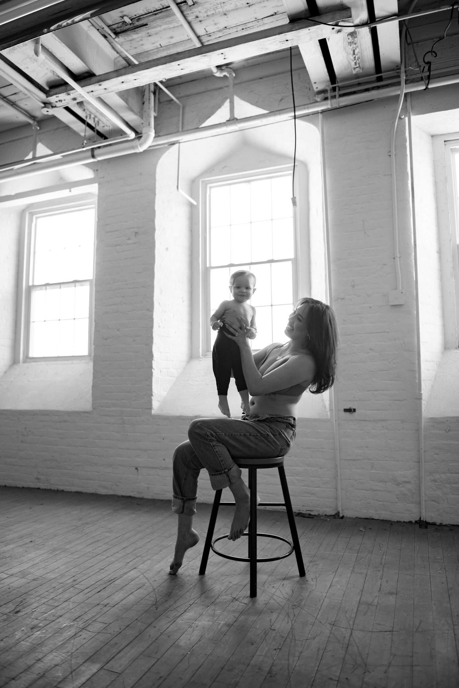 A sequence of black and white photos showing a figure seated in a chair in an empty room with wooden floors.