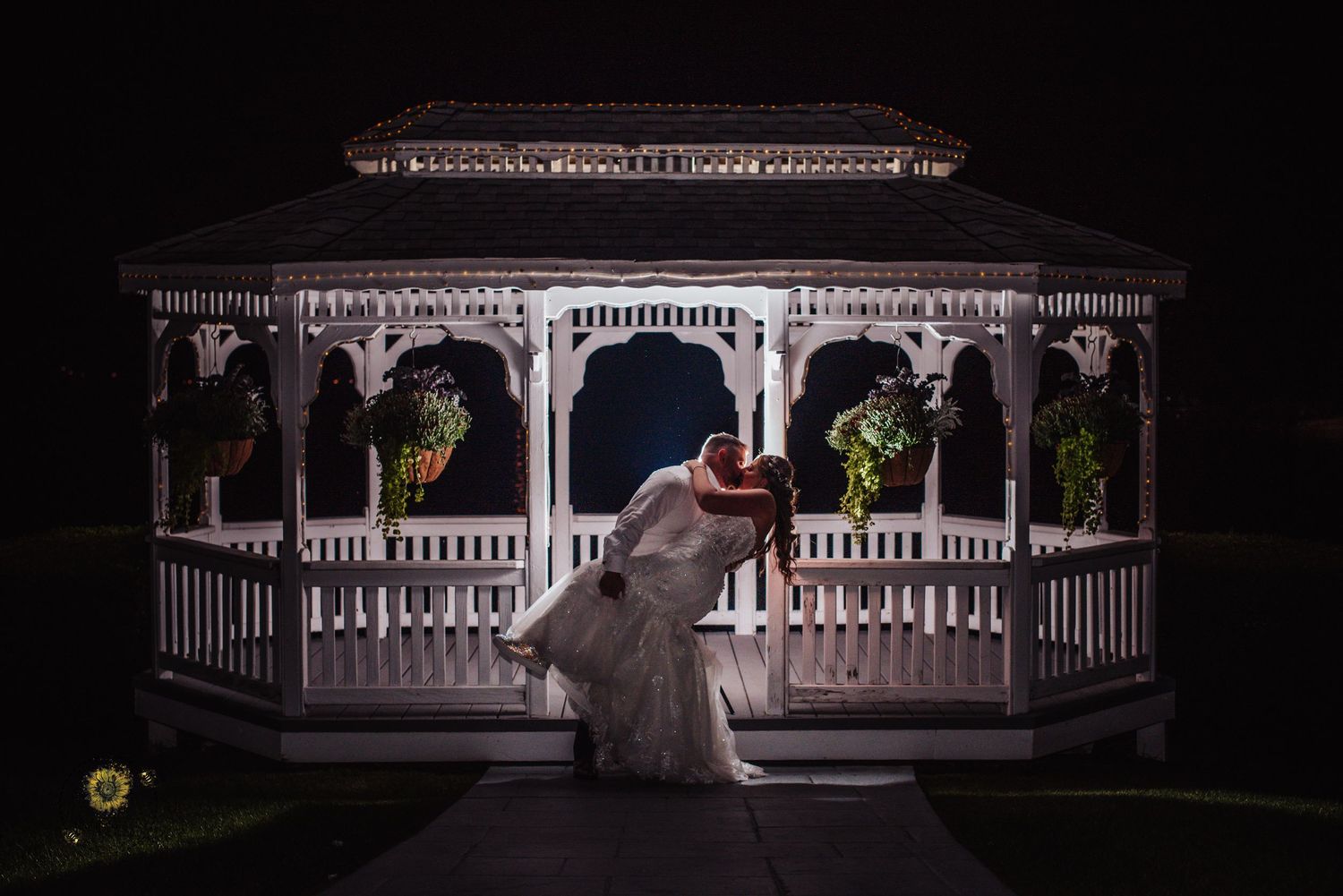 Dramatic nighttime wedding photos at an elegant white gazebo.