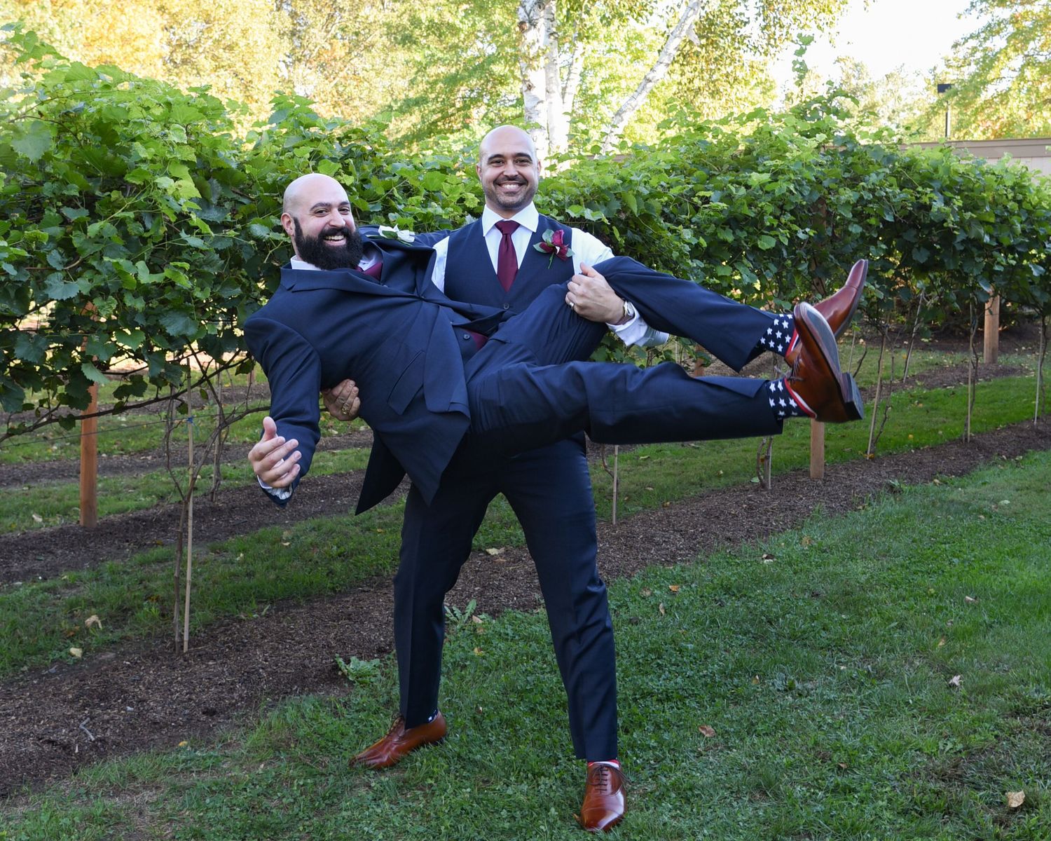 Groomsmen performing fun jumping poses for wedding photos outdoors.