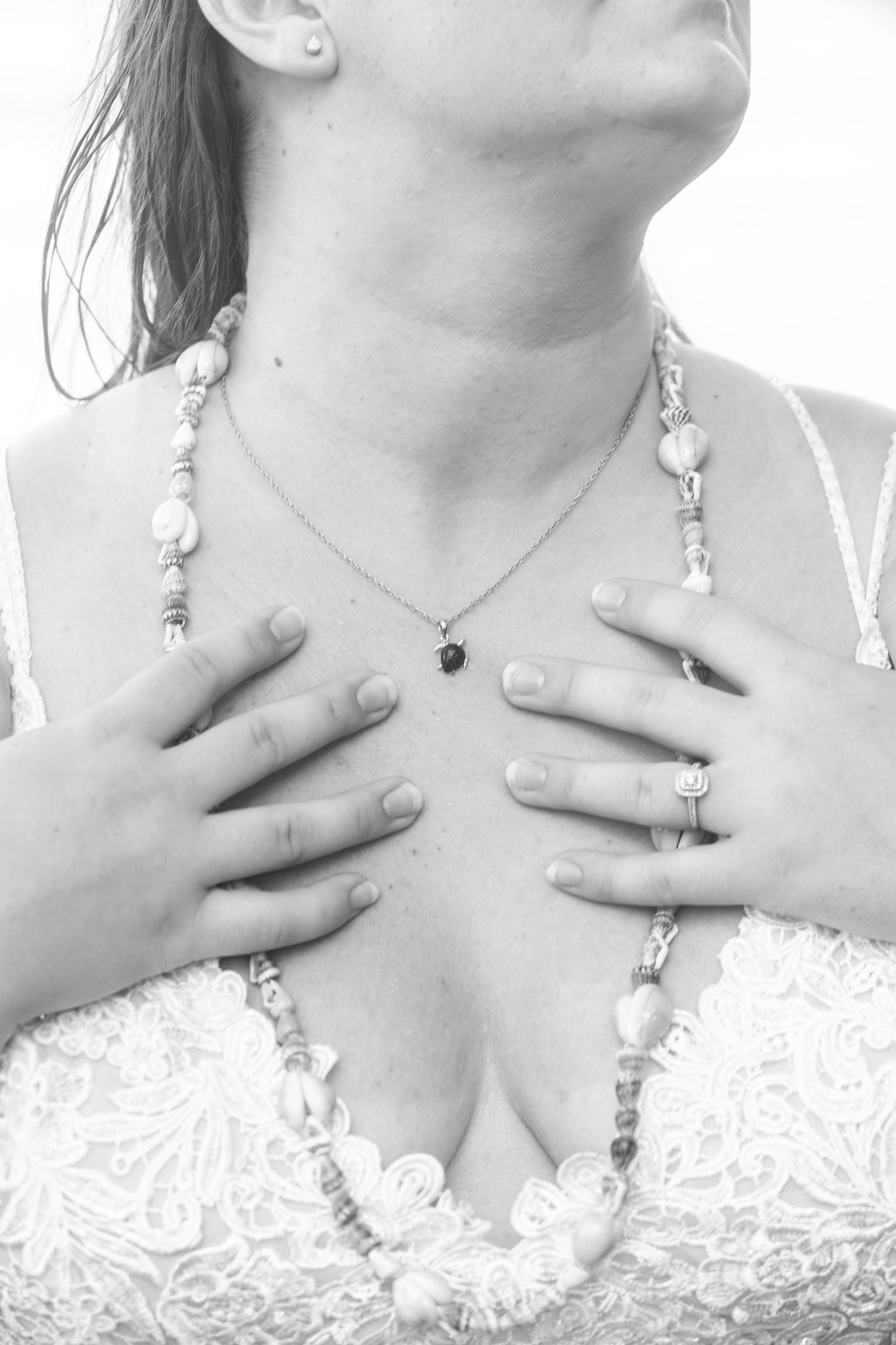Close-up detail shots of bridal jewelry and lace dress neckline in black and white.
