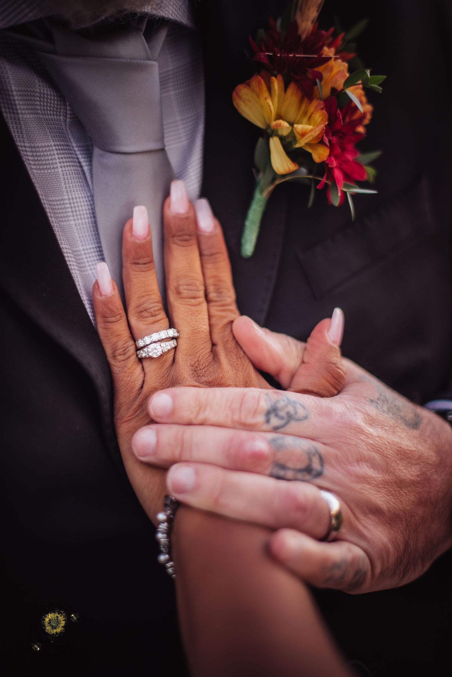 Close-up shots of wedding rings and tattooed hands holding flowers.